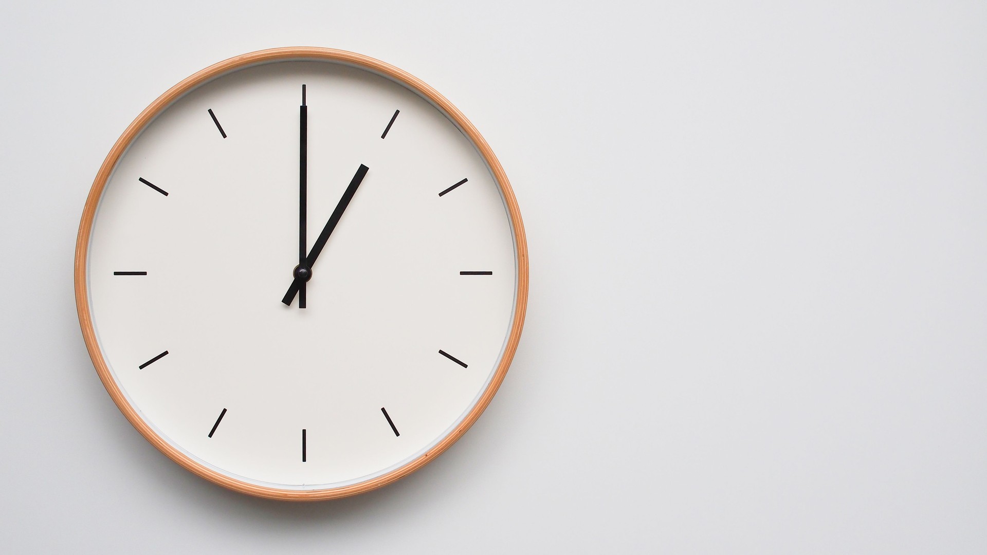 Minimalist wooden Wall Clock on White Wooden Surface with Space for Text  Time Set at 13.00/01.00